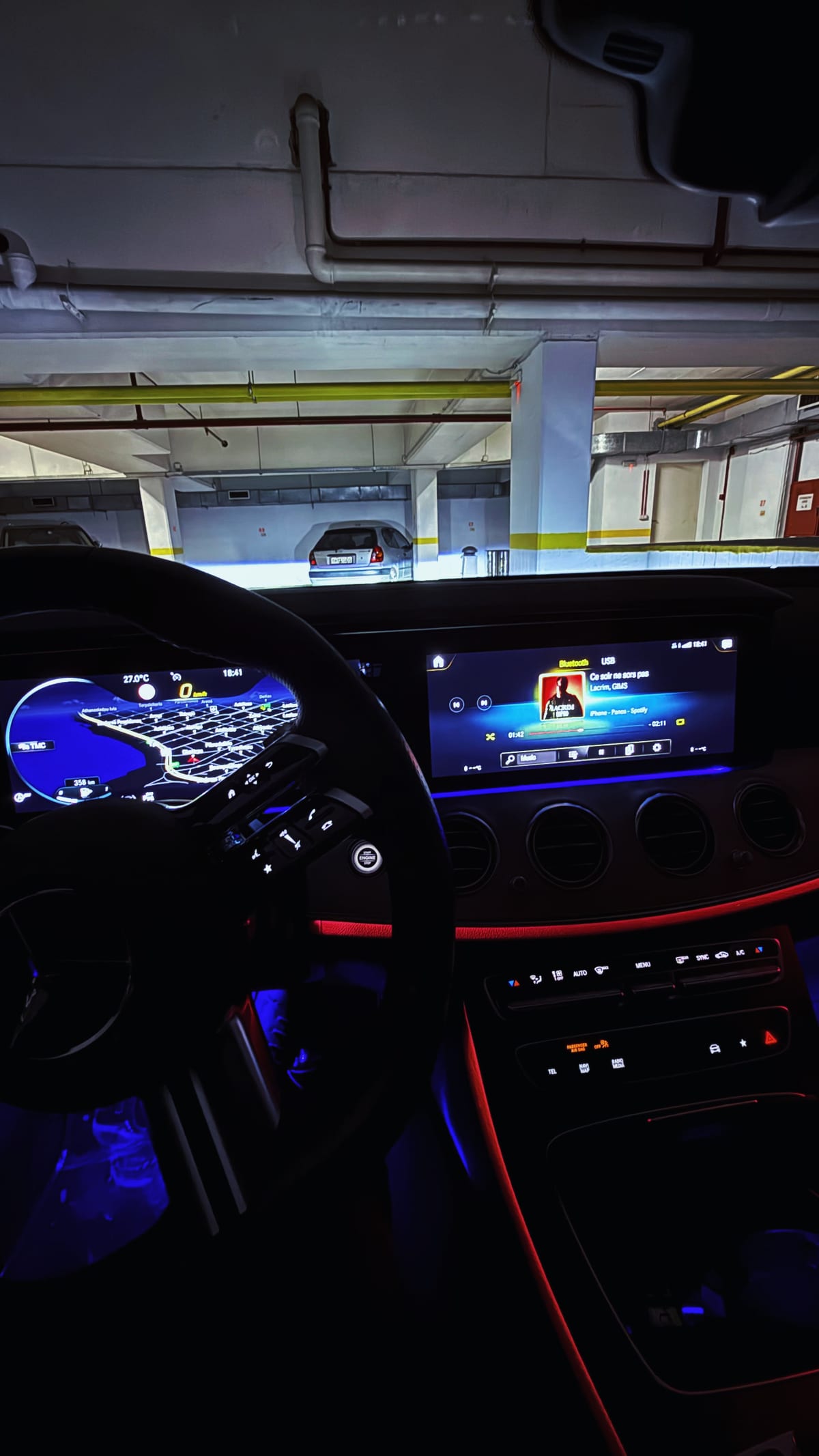 The taxi's lit cabin at night with satellite navigation on the instrument cluster and blue ambient lighting